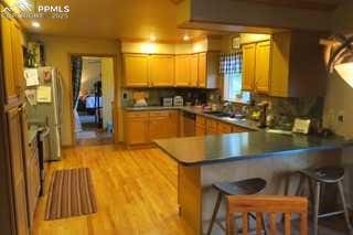 kitchen featuring light wood-style floors, a kitchen bar, a peninsula, and stainless steel appliances