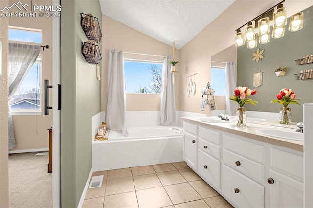 bathroom with a healthy amount of sunlight, visible vents, a sink, and vaulted ceiling