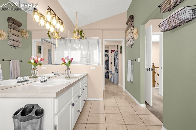 full bathroom with vanity, baseboards, a spacious closet, tile patterned flooring, and lofted ceiling