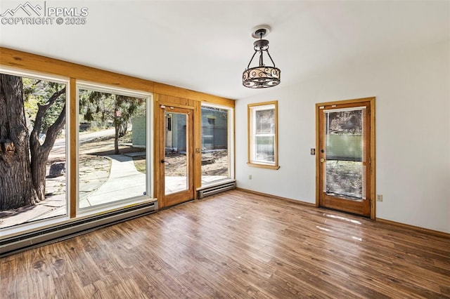 doorway to outside featuring a baseboard radiator, baseboards, and wood finished floors