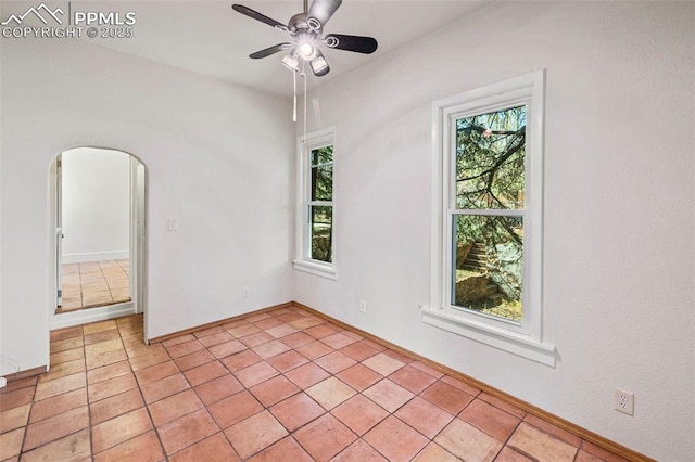 unfurnished room featuring ceiling fan, light tile patterned floors, and a wealth of natural light