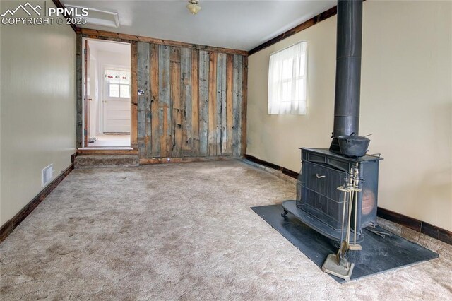 2354 Valley Forge Rd, Colorado Springs, CO 80907 - unfurnished living room with plenty of natural light, carpet flooring, a wood stove, and baseboards