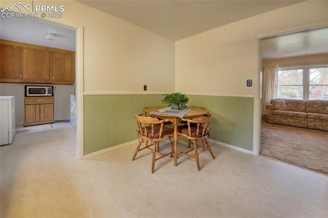 2354 Valley Forge Rd, Colorado Springs, CO 80907 - dining area with wooden walls, wainscoting, independent washer and dryer, and light colored carpet