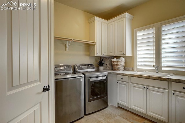 washroom featuring a sink, independent washer and dryer, and cabinet space
