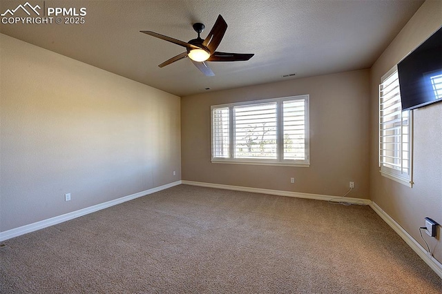 empty room featuring carpet, baseboards, a ceiling fan, and visible vents