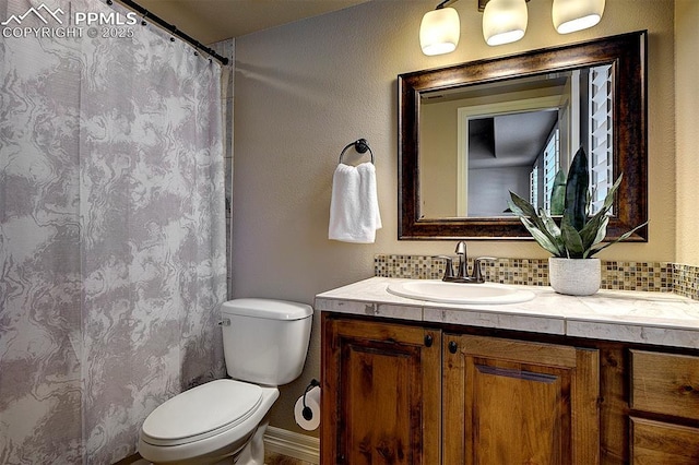 full bath with curtained shower, vanity, and toilet