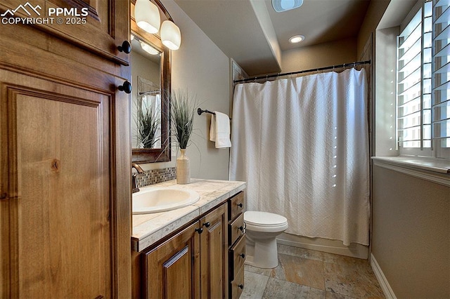 full bath featuring tasteful backsplash, baseboards, toilet, vanity, and stone tile floors