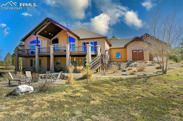 back of property with a patio area, stairway, stucco siding, and a deck