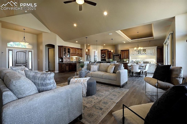 living room featuring arched walkways, recessed lighting, ceiling fan with notable chandelier, dark wood-type flooring, and high vaulted ceiling