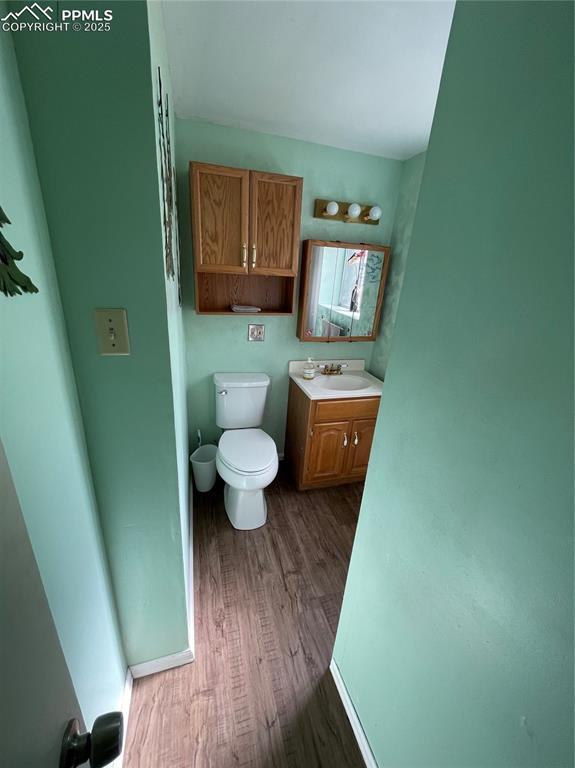 4620 Scenic Cir, Colorado Springs, CO 80917 - bathroom with wood finished floors, toilet, and vanity
