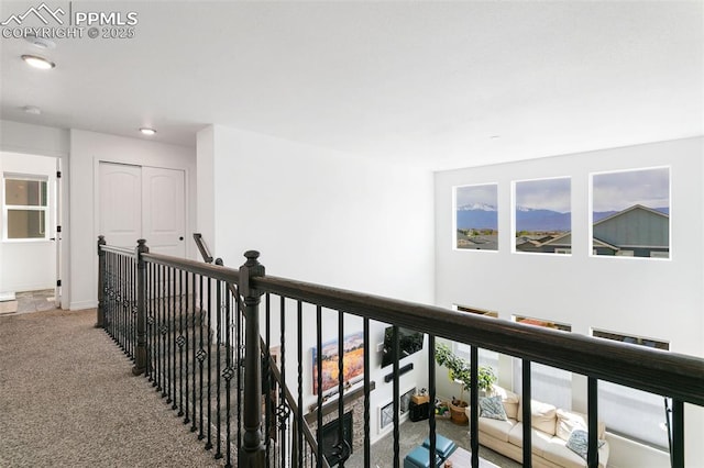 hallway featuring carpet flooring, recessed lighting, and an upstairs landing