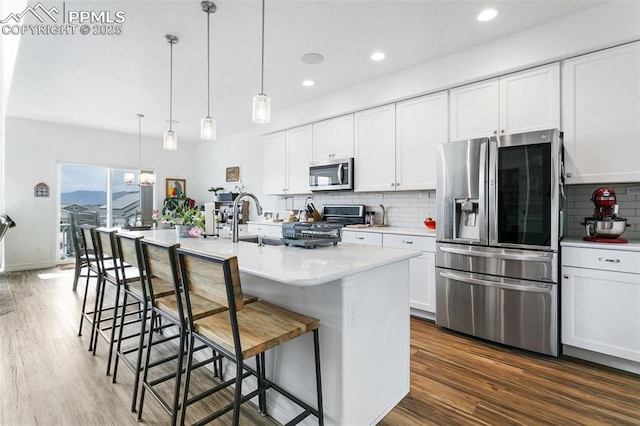 kitchen featuring appliances with stainless steel finishes, backsplash, dark wood finished floors, light countertops, and recessed lighting