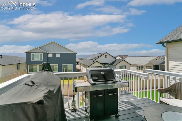wooden terrace featuring a residential view and area for grilling