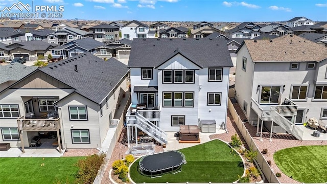 back of house with a trampoline, a residential view, a patio, and stairway