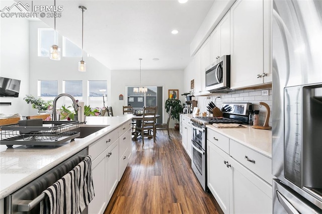 kitchen with appliances with stainless steel finishes, dark wood-type flooring, a sink, light countertops, and recessed lighting