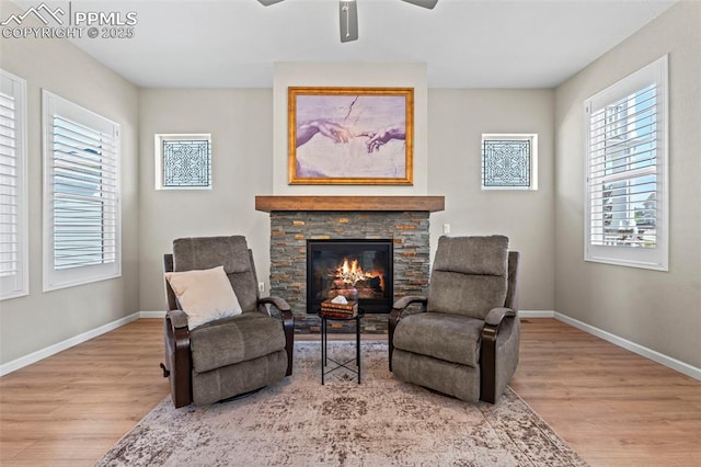 48 Mayflower Park Pl, Colorado Springs, CO 80905 - living area featuring wood finished floors, baseboards, ceiling fan, and a stone fireplace