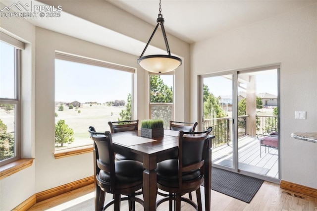 dining space featuring light wood-style flooring, visible vents, and baseboards