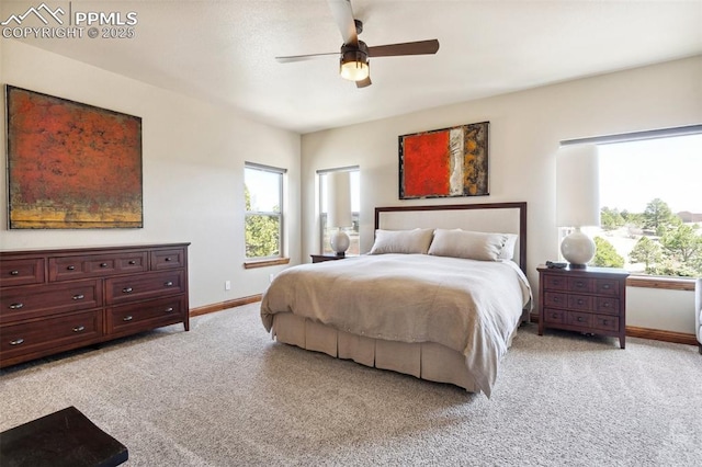 bedroom featuring baseboards, light colored carpet, and multiple windows