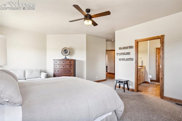 bedroom with light carpet, ensuite bathroom, baseboards, and a ceiling fan