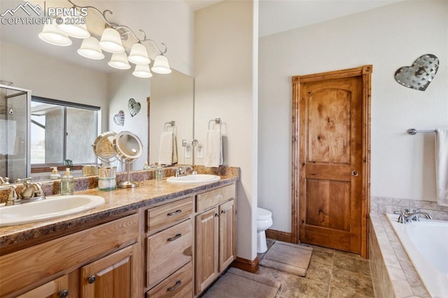 full bath featuring a bath, double vanity, toilet, and a sink