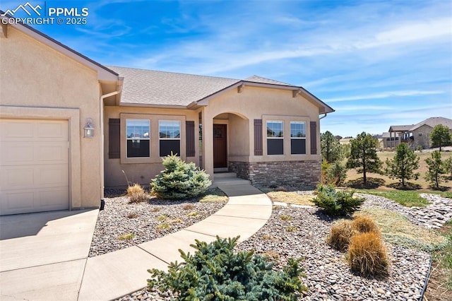 view of front of property with stucco siding, an attached garage, stone siding, and a shingled roof