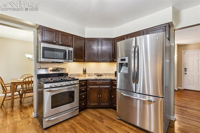 620 Jayton Dr, Colorado Springs, CO 80911 - kitchen featuring dark brown cabinets, wood finished floors, and stainless steel appliances