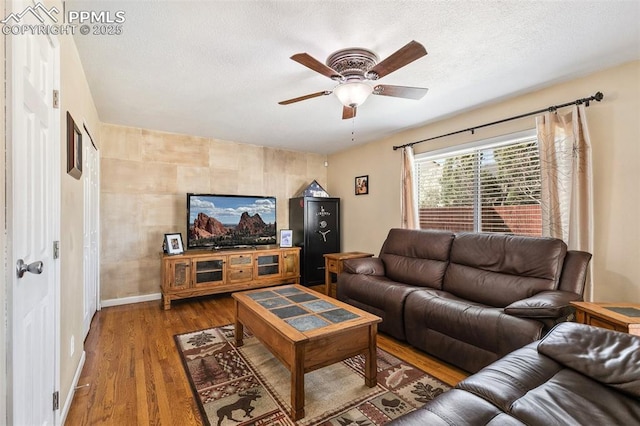 620 Jayton Dr, Colorado Springs, CO 80911 - living room featuring wood finished floors, a textured ceiling, baseboards, and ceiling fan