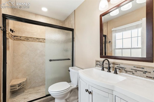 620 Jayton Dr, Colorado Springs, CO 80911 - full bath with a tile shower, toilet, vanity, and backsplash