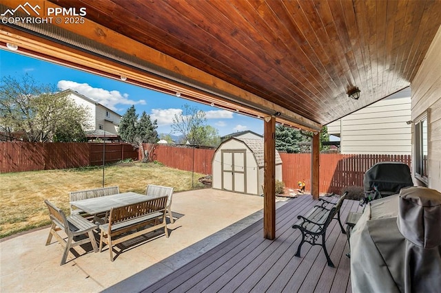 620 Jayton Dr, Colorado Springs, CO 80911 - deck with a lawn, outdoor dining space, a fenced backyard, an outdoor structure, and a storage unit