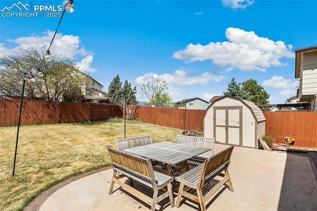 620 Jayton Dr, Colorado Springs, CO 80911 - view of patio / terrace with outdoor dining space, a fenced backyard, a storage unit, and an outbuilding