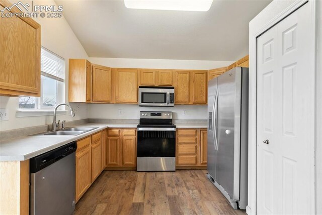 8246 Pinegate Dr, Colorado Springs, CO 80925 - kitchen with appliances with stainless steel finishes, light wood-type flooring, light countertops, and vaulted ceiling