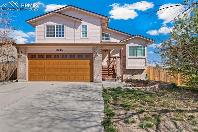 8246 Pinegate Dr, Colorado Springs, CO 80925 - view of front of home with brick siding, a garage, concrete driveway, and stairway