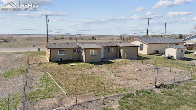 back of property with roof with shingles, fence, and stucco siding