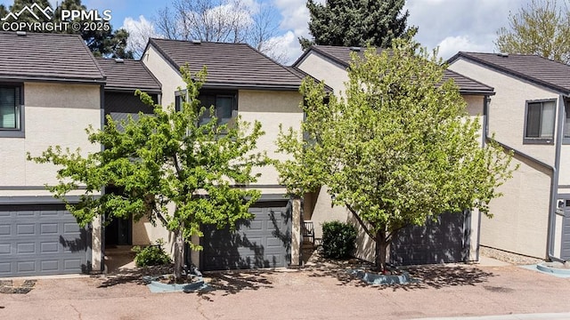 4823 Bluestem Dr, Colorado Springs, CO 80917 - view of front of home featuring stucco siding, a garage, and a tiled roof