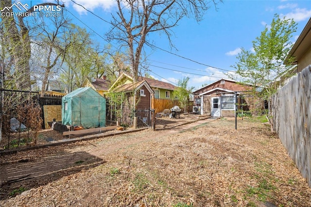 1903 W Colorado Ave, Colorado Springs, CO 80904 - view of yard with a fenced backyard, an outbuilding, and a greenhouse