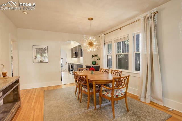 1866 S Pennsylvania St, Denver, CO 80210 - dining area featuring arched walkways, light wood-style floors, and a chandelier