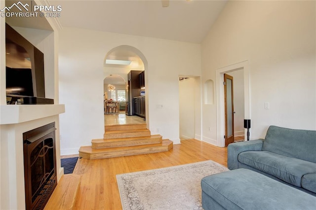 1866 S Pennsylvania St, Denver, CO 80210 - living room with arched walkways, wood finished floors, a fireplace, stairway, and high vaulted ceiling