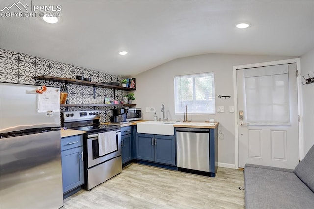 1866 S Pennsylvania St, Denver, CO 80210 - kitchen featuring stainless steel appliances, blue cabinetry, open shelves, light wood finished floors, and lofted ceiling