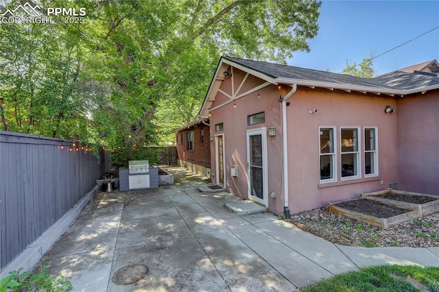 1866 S Pennsylvania St, Denver, CO 80210 - view of side of home with stucco siding, a patio, and a fenced backyard