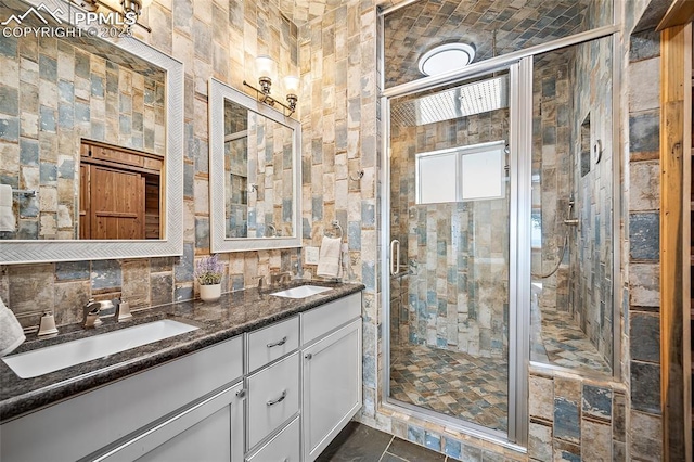 bathroom with a shower stall, a sink, and double vanity