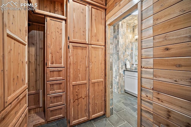 interior space with stone finish flooring and wood walls