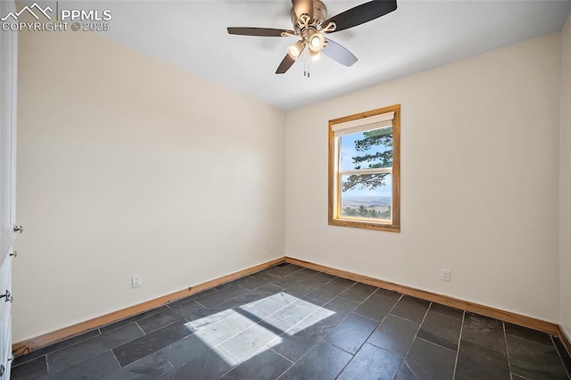 unfurnished room with stone finish flooring, baseboards, and ceiling fan