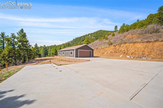 view of front of property featuring a view of trees