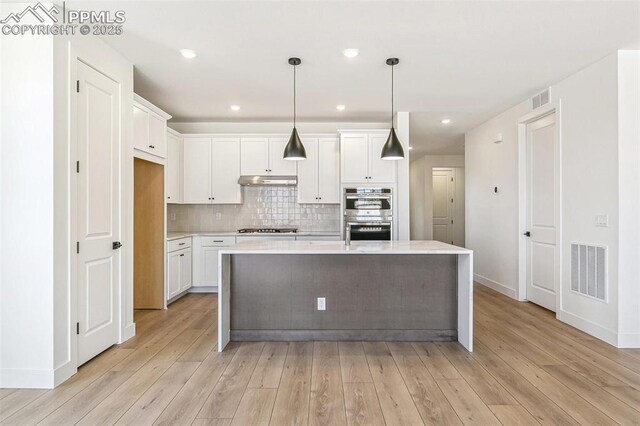 4331 Soapberry Pl, Castle Rock, CO 80108 - kitchen with white cabinets, visible vents, appliances with stainless steel finishes, light countertops, and light wood finished floors