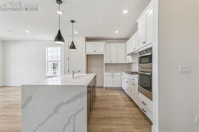 4331 Soapberry Pl, Castle Rock, CO 80108 - kitchen with white cabinets, tasteful backsplash, light wood-type flooring, and a sink
