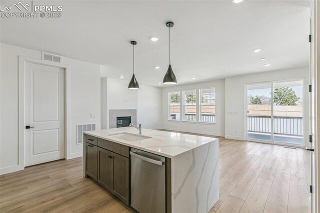4331 Soapberry Pl, Castle Rock, CO 80108 - kitchen with visible vents, dishwasher, a sink, open floor plan, and light wood-type flooring