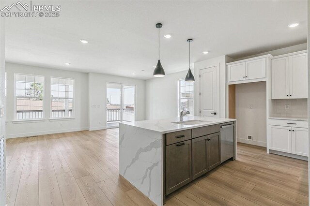 4331 Soapberry Pl, Castle Rock, CO 80108 - kitchen featuring dishwasher, white cabinetry, a sink, and light wood-style flooring
