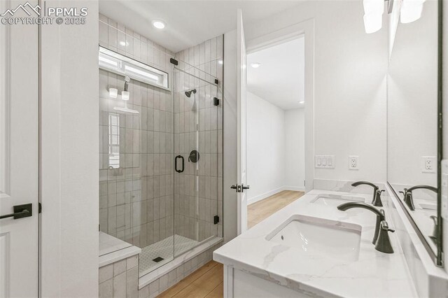 4331 Soapberry Pl, Castle Rock, CO 80108 - full bath featuring a shower stall, double vanity, a sink, and wood finished floors