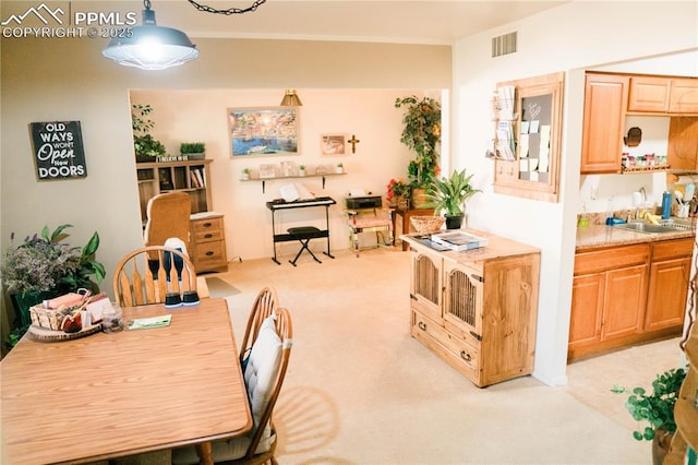 dining area with visible vents, light colored carpet, and indoor wet bar