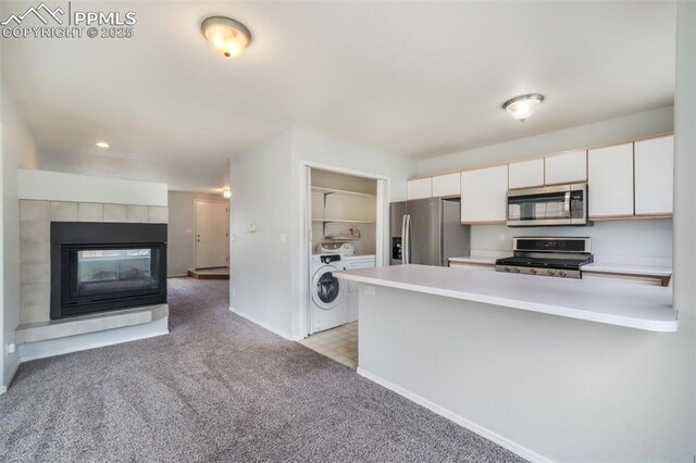 6142 Colony Cir, Colorado Springs, CO 80919 - kitchen with stainless steel appliances, light carpet, a peninsula, white cabinetry, and independent washer and dryer